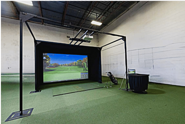 AG Modular Enclosure showcasing a golf simulator setup with a screen and practice equipment in an indoor space.
